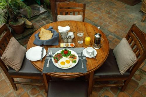 a wooden table with a plate of food on it at Ambassador Garden Home in Kathmandu