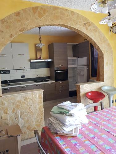 a kitchen with a counter and a table with a red stool at Appartamento e Attico Epi in Lucca Sicula