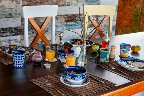 a table with plates and bowls of food and orange juice at Serrania del Viento in Barichara