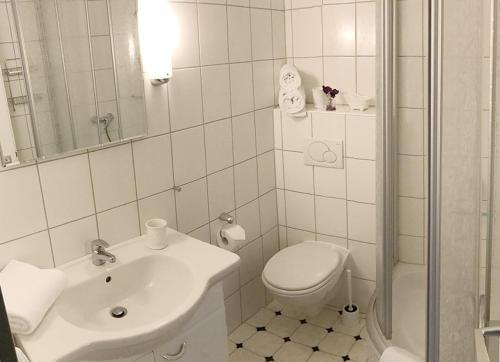 ein weißes Bad mit einem WC und einem Waschbecken in der Unterkunft 2Zi-Ferienwohnung am Südstrand mit eigenem Parkplatz perfekt für Familie in Burgtiefe auf Fehmarn 