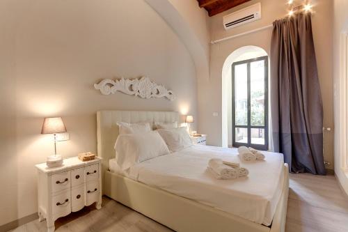 sypialnia z dużym białym łóżkiem i oknem w obiekcie Courtyard Suite we Florencji