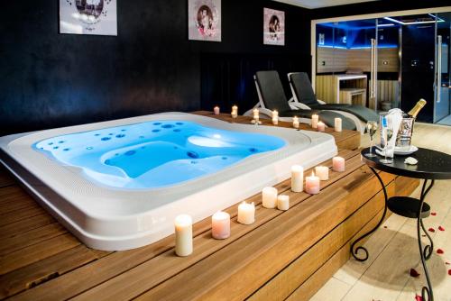 a jacuzzi tub in a living room with candles at Grand Hotel Gallia & Londres in Lourdes