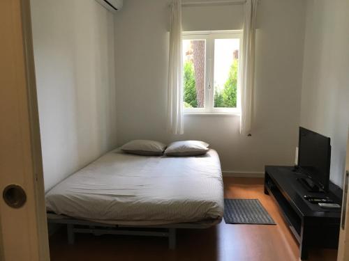 Habitación pequeña con cama y ventana en Casas do Cabedelo, en Darque