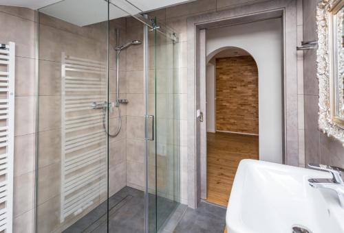 a bathroom with a glass shower and a sink at Alpenhaus Dachstein.Zauber in Abtenau