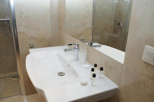 a bathroom with a white sink and a shower at Arte in Brzeg