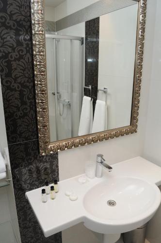 a bathroom with a white sink and a mirror at Arte in Brzeg
