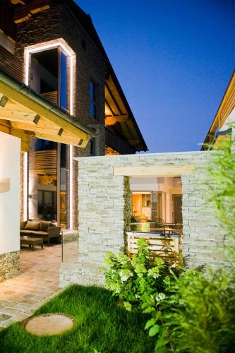 a brick house with a patio and a couch at Hotel Birkenhof in Saalbach Hinterglemm