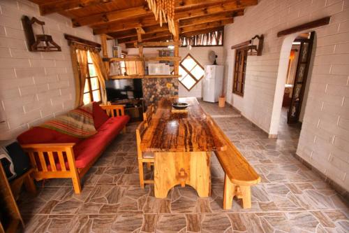 sala de estar con mesa de madera y sofá en Cabaña Media Luna en San Pedro de Atacama