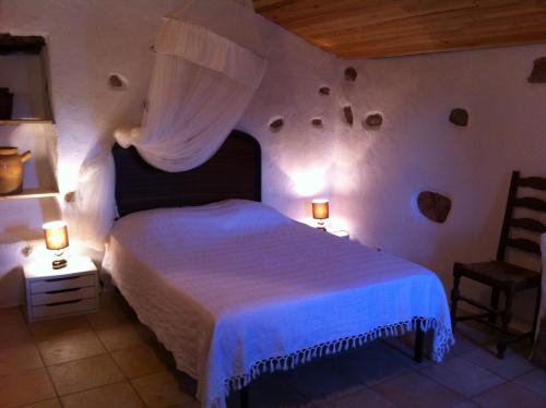 1 dormitorio con 1 cama, 2 lámparas y 1 silla en Caseddu di Chjarastella en Figari