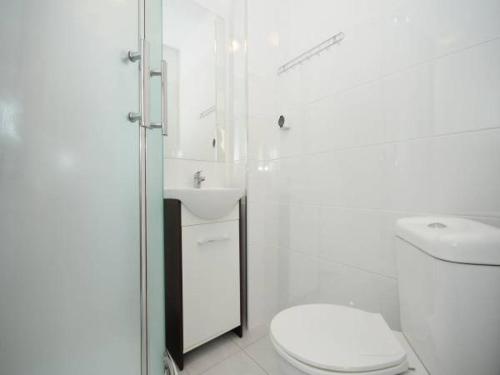 biała łazienka z toaletą i umywalką w obiekcie Willa Zawada w Rewalu
