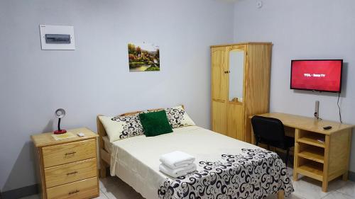 1 dormitorio con 1 cama, escritorio, 1 cama y 1 silla en Sunburst, en Arnos Vale
