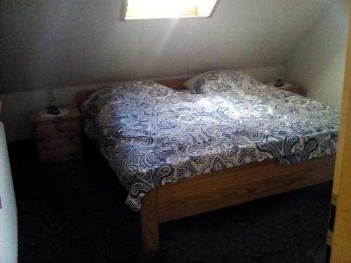 a bedroom with a bed with a blue and white comforter at up de Pfahldeichsweg in Neugarmssiel