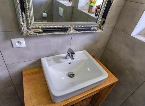 a bathroom with a white sink and a mirror at Alpenhaus Dachstein.Zauber in Abtenau