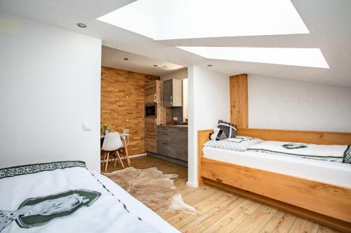 a bedroom with two beds and a kitchen at Alpenhaus Dachstein.Zauber in Abtenau