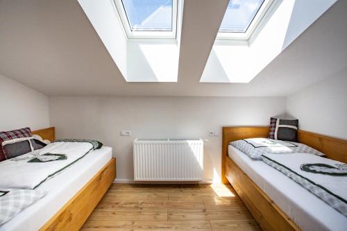 two beds in a attic room with skylights at Alpenhaus Dachstein.Zauber in Abtenau