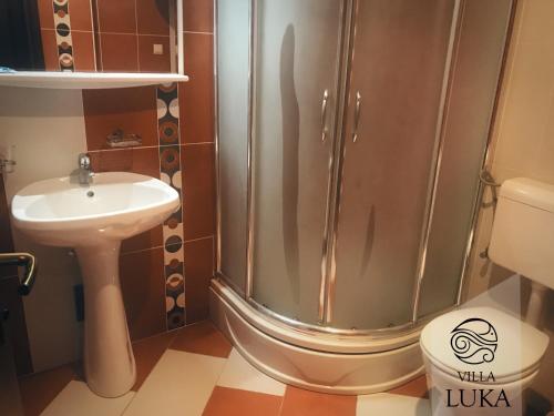 a bathroom with a shower and a sink and a toilet at Apartments Villa Luka in Sveti Stefan