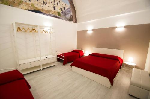 マテーラにあるCasa Du Mattneerのベッドルーム1室(赤いベッド1台、赤い椅子2脚付)