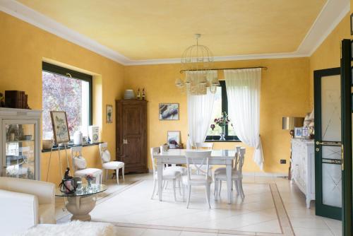 une salle à manger avec une table et des chaises blanches dans l'établissement B&B La Provenzale, à Tornolo