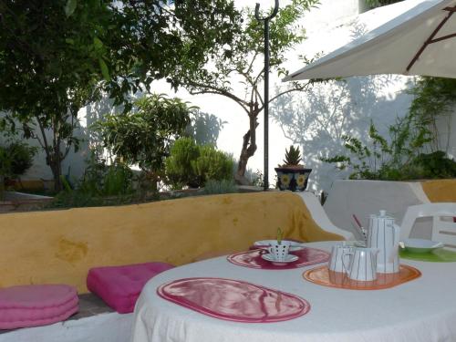 a table with pink and white plates on it at Casa rústica com jardim privado in Tavira