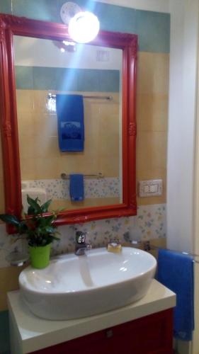 a bathroom sink with a mirror and a potted plant at Casa vacanze Elisir in Specchia