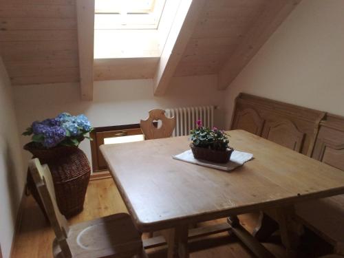 a dining room with a wooden table with flowers on it at Antico Maso in Lavarone