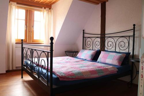 um quarto com uma cama com uma moldura preta e uma janela em Spatzenhof em Weiltingen