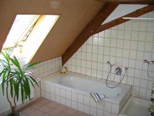a bath tub in a bathroom with a window at Spatzenhof in Weiltingen