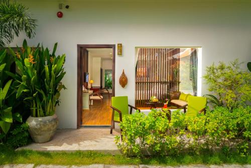 a living room with green chairs and a table at Sabara Angkor Resort & Spa in Siem Reap