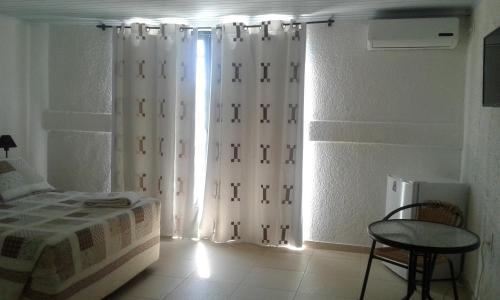 a bedroom with a bed and a window with curtains at Petit Rivera Hotel in Rivera