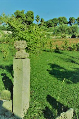 a stone pillar in the middle of a field of grass at Giardino D'Oriente in Otranto