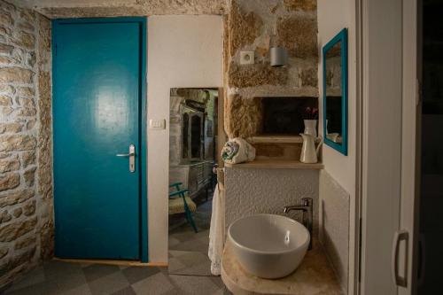 a bathroom with a blue door and a sink at Apartments Miki in Komiža