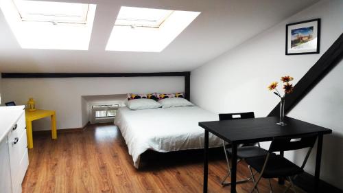 a bedroom with a bed and a table and skylights at Nice Attic Studio Close to Old Town Air Conditioning - Klimatyzacja in Krakow
