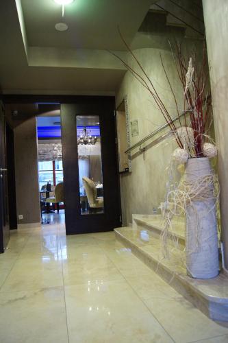 a lobby with a large vase with a plant in it at Arte in Brzeg