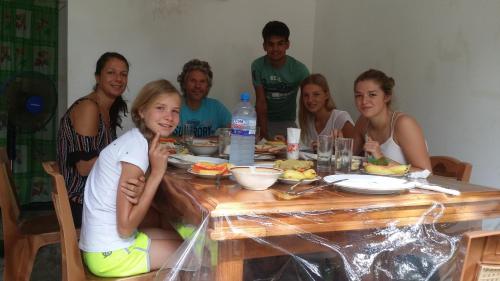 un gruppo di persone seduti intorno a un tavolo di legno di Rich Resort & Restaurant a Anuradhapura