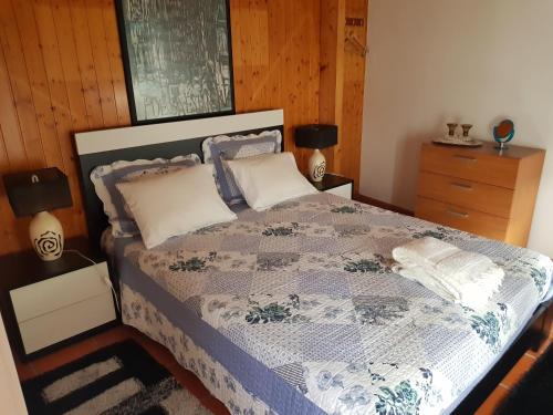 1 dormitorio con 1 cama con edredón azul y blanco en Casa do Adro en Viana do Castelo