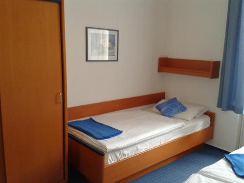 a small bedroom with a small bed with blue pillows at Haus Alexander in Heringsdorf
