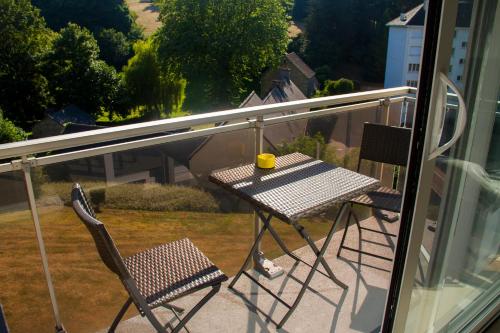 een tafel en stoelen op een balkon met uitzicht op een tuin bij T1 tout équipé avec balcon & parking ! in Cherbourg en Cotentin