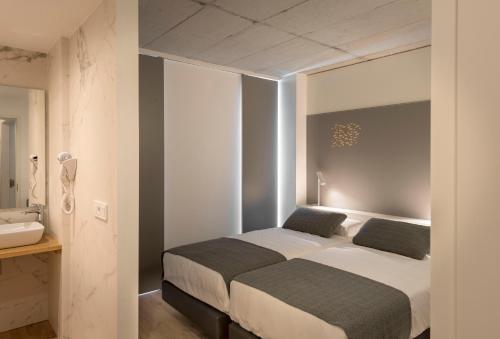1 Schlafzimmer mit 2 Betten und einem Waschbecken in der Unterkunft Hotel SempreFisterra in Kap Finisterre