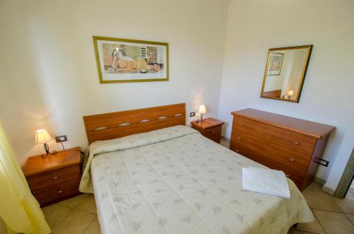 1 dormitorio con 1 cama, 2 vestidores y espejo en A.I.R. Castelsardo Borgo di Mare, en Castelsardo