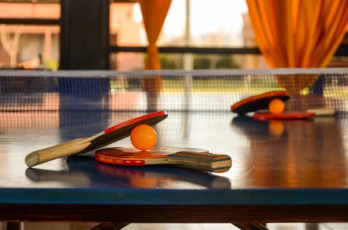 two ping pong rackets and oranges on a table at Complejo Atrapasueños in San Rafael