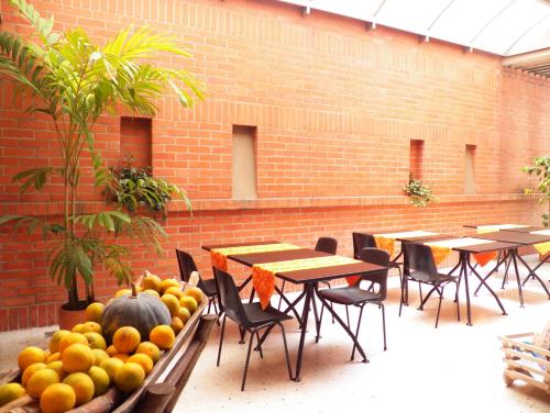 a group of tables and chairs with fruits and vegetables at Hotel Casa Santa Monica Norte in Cali