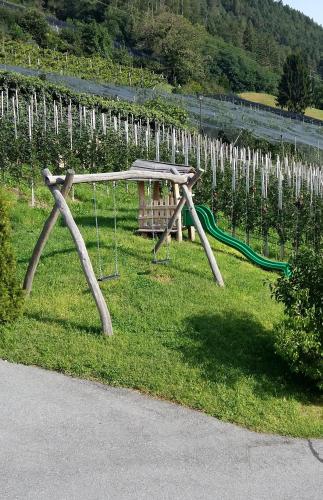 a park with a swing set in the grass at Sonnenhof in Rifiano