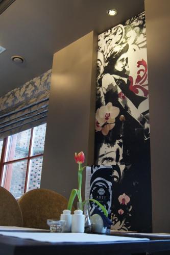 a mirror on a wall with a painting of a woman at Arte in Brzeg