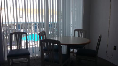 a table and chairs in a room with a window at Tide Winds Motel in Wildwood