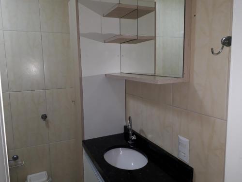 a bathroom with a sink and a mirror at Ótimo Apto. 180 metros da Praia in Balneário Camboriú