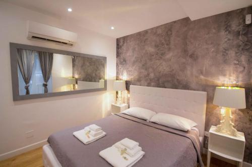 ein Schlafzimmer mit einem Bett mit zwei weißen Handtüchern darauf in der Unterkunft Apartment Via del Corso in Rom