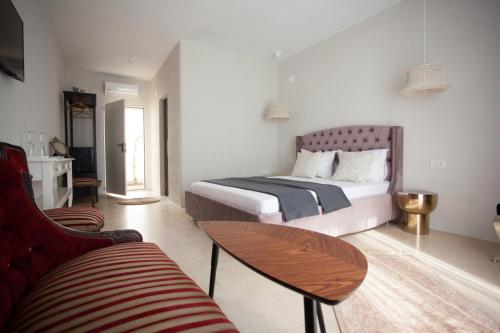 a bedroom with a bed and a table and a couch at Elia Vama Veche (Adults Only) in Vama Veche