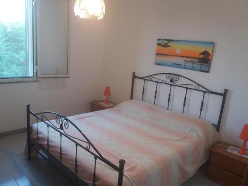 sypialnia z łóżkiem i obrazem na ścianie w obiekcie Casa Anna in riva al mare w mieście Mazara del Vallo
