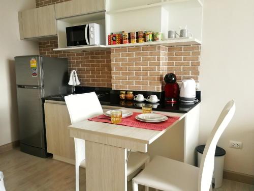 a small kitchen with a table and a microwave at Diamant Modern Room Condominium Resort in Chiang Mai