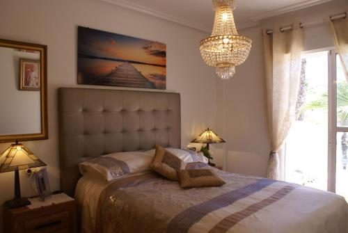 プレヤス・デ・オリフエラにあるOriheula Costa Cabo Roig 6のベッドルーム1室(ベッド1台、シャンデリア付)